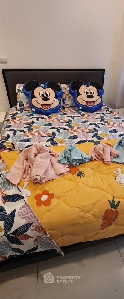Cozy bedroom with colorful bedding and playful character pillows