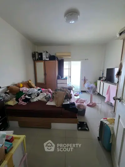 Cozy bedroom with cluttered decor and natural light from window