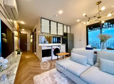 Modern living room with open kitchen and city view balcony, featuring stylish decor and appliances.