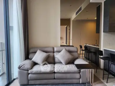 Modern living room with plush sofa and open kitchen layout in luxury apartment