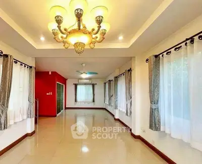 Spacious living room with elegant chandelier and large windows for natural light.