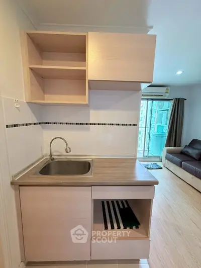Compact kitchen with open shelving and modern sink in cozy apartment
