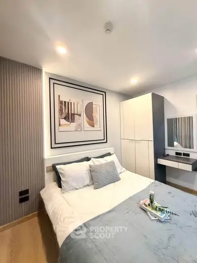 Modern bedroom with stylish decor and cozy ambiance, featuring a comfortable bed and elegant furnishings.