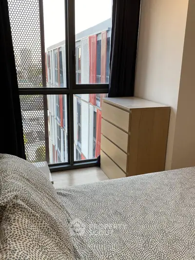 Modern bedroom with large window and stylish dresser in urban apartment