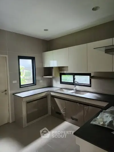 Modern kitchen with sleek cabinetry and large windows for natural light.