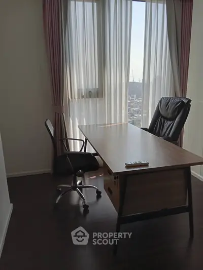 Bright study room with city view, featuring modern desk and comfortable chairs.