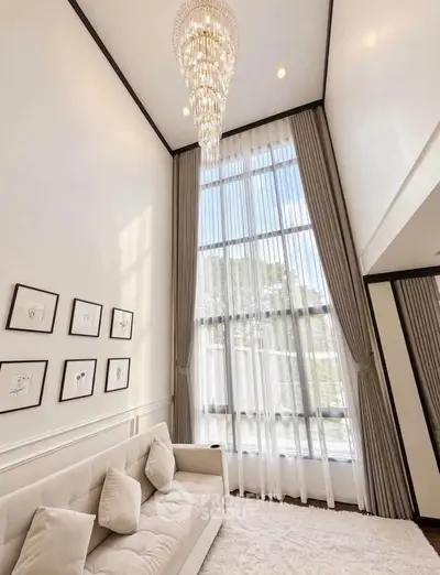 Luxurious living room with high ceilings and elegant chandelier, perfect for modern living.