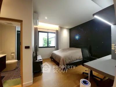 Modern bedroom with galaxy-themed wall and ensuite bathroom