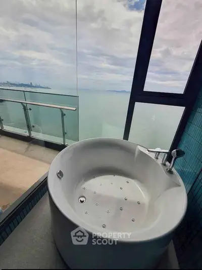 Luxurious bathroom with stunning ocean view and modern round bathtub.