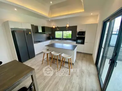 Modern kitchen with island, sleek appliances, and open layout in a stylish home.