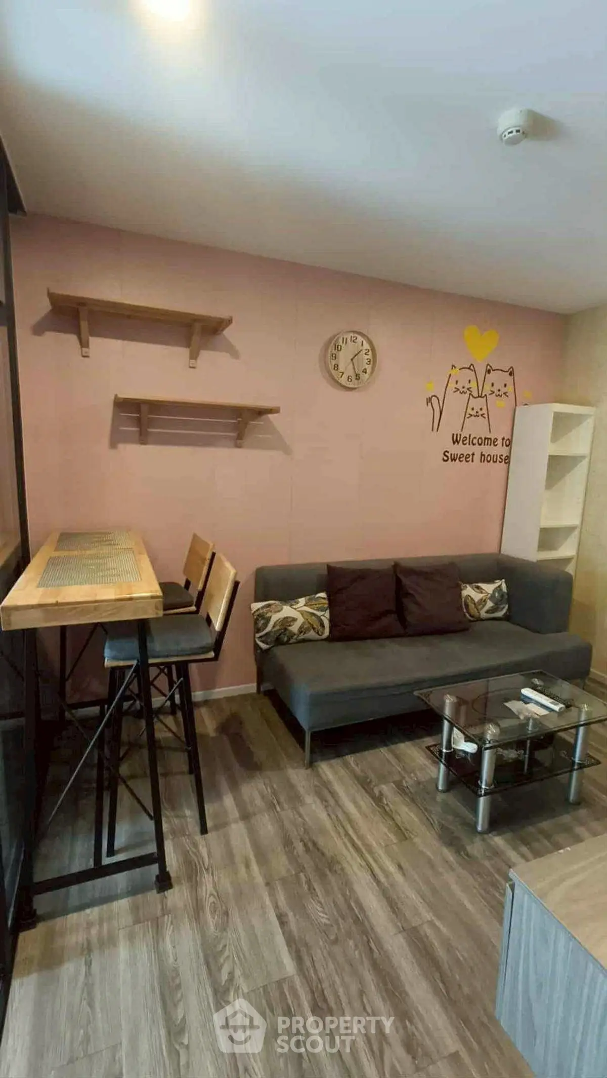 Charming living room with cozy sofa, stylish bar table, and wall decor in modern apartment.