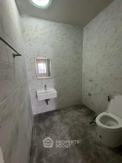 Spacious bathroom with modern fixtures and tiled walls, perfect for a contemporary home.