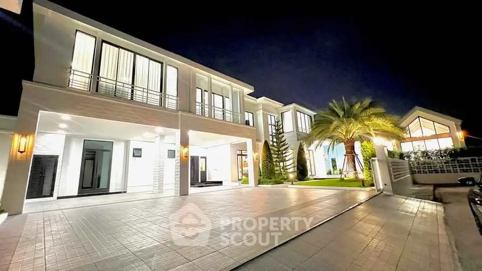 Luxurious modern mansion with elegant lighting and spacious driveway at night