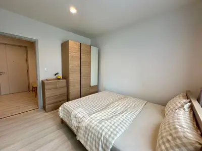 Cozy bedroom with modern wardrobe and checkered bedding in a minimalist design.