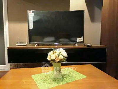 Cozy living room with modern TV setup and elegant floral centerpiece.