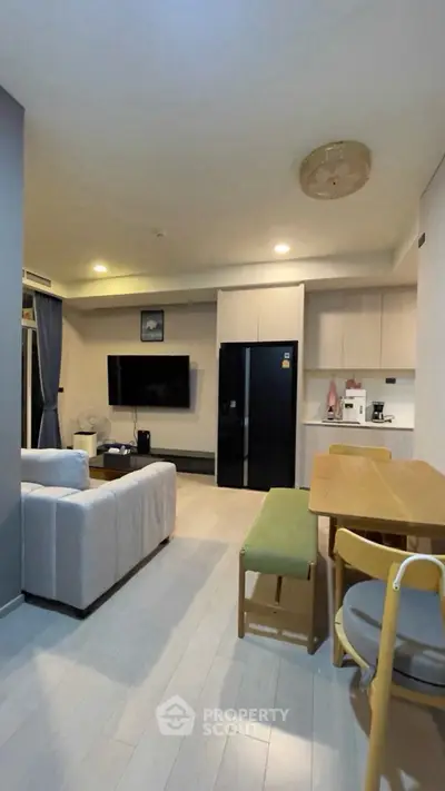 Modern living room with open kitchen, stylish furniture, and cozy lighting in a contemporary apartment.