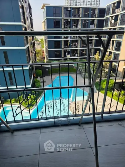 Modern apartment balcony with pool view in urban setting, perfect for relaxation and leisure.