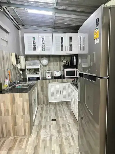 Modern kitchen with sleek appliances and ample storage in a stylish home.