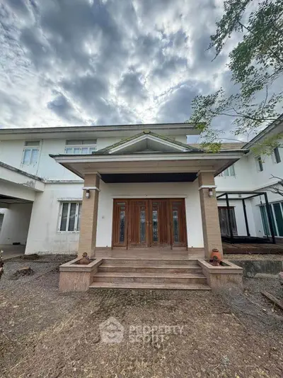 Stunning two-story home with elegant entrance and dramatic sky backdrop