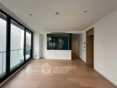 Spacious modern living room with large windows and wooden flooring
