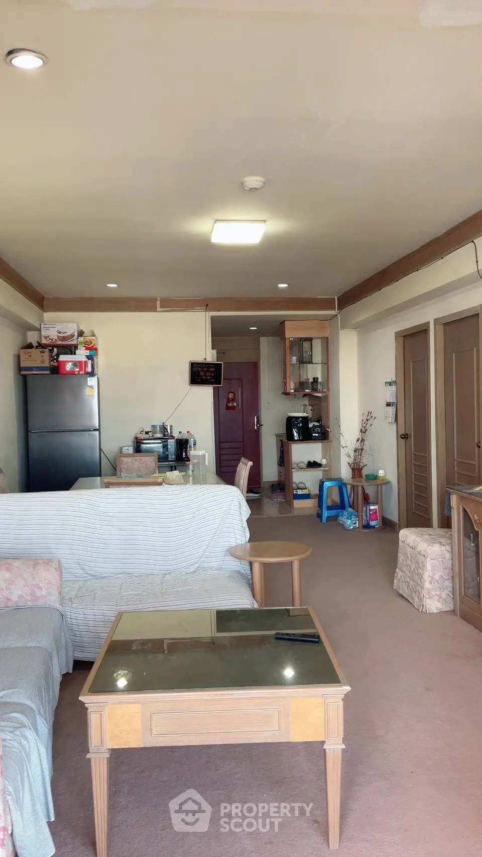 Spacious living room with cozy seating and modern decor in a well-lit apartment.