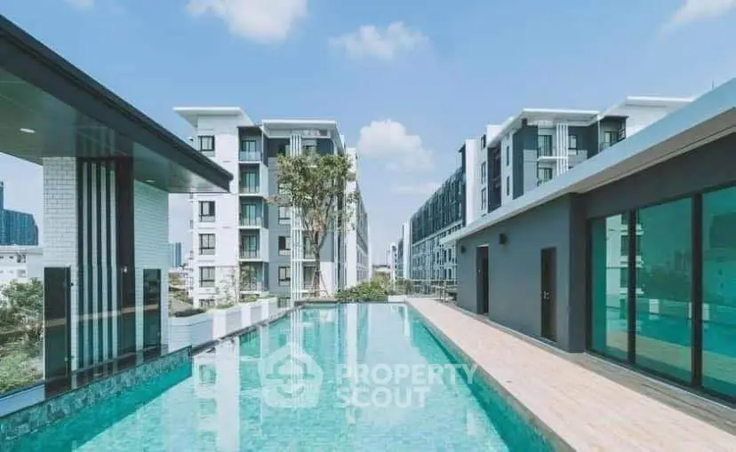 Luxurious rooftop pool with stunning cityscape views in modern apartment complex.