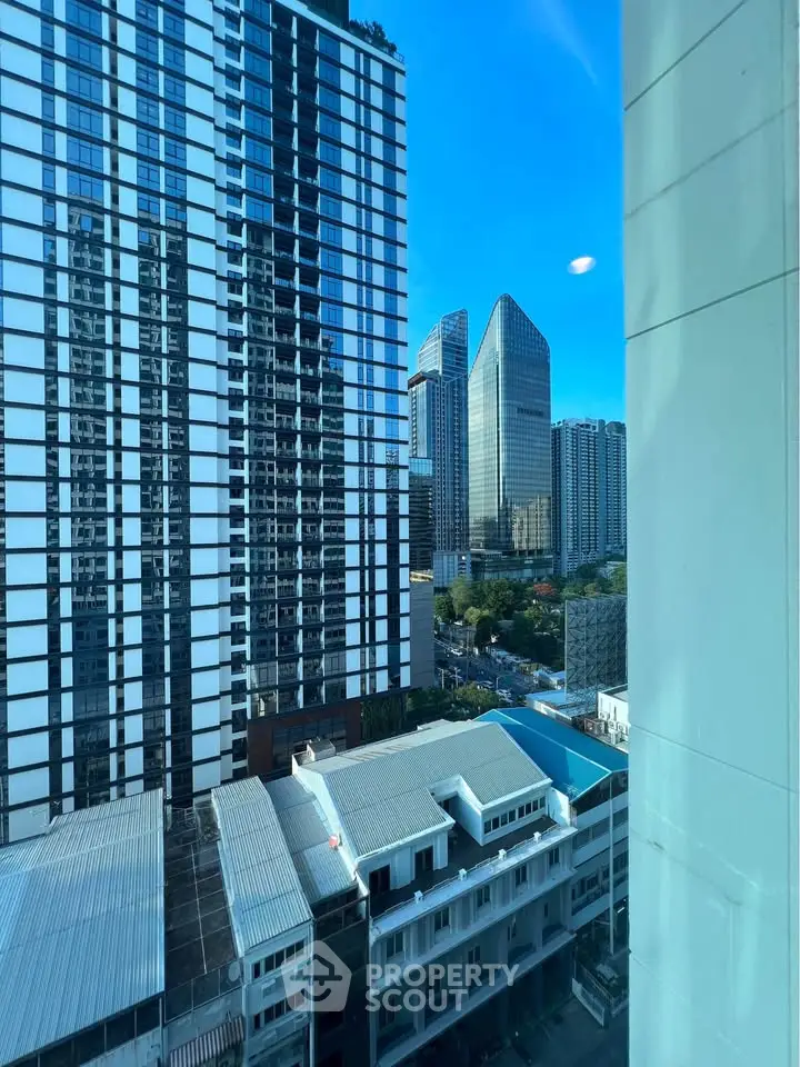 Stunning urban view from high-rise building window showcasing modern architecture and city skyline.
