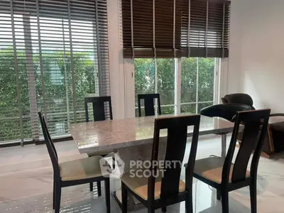 Elegant dining area with marble table and garden view, perfect for family gatherings.