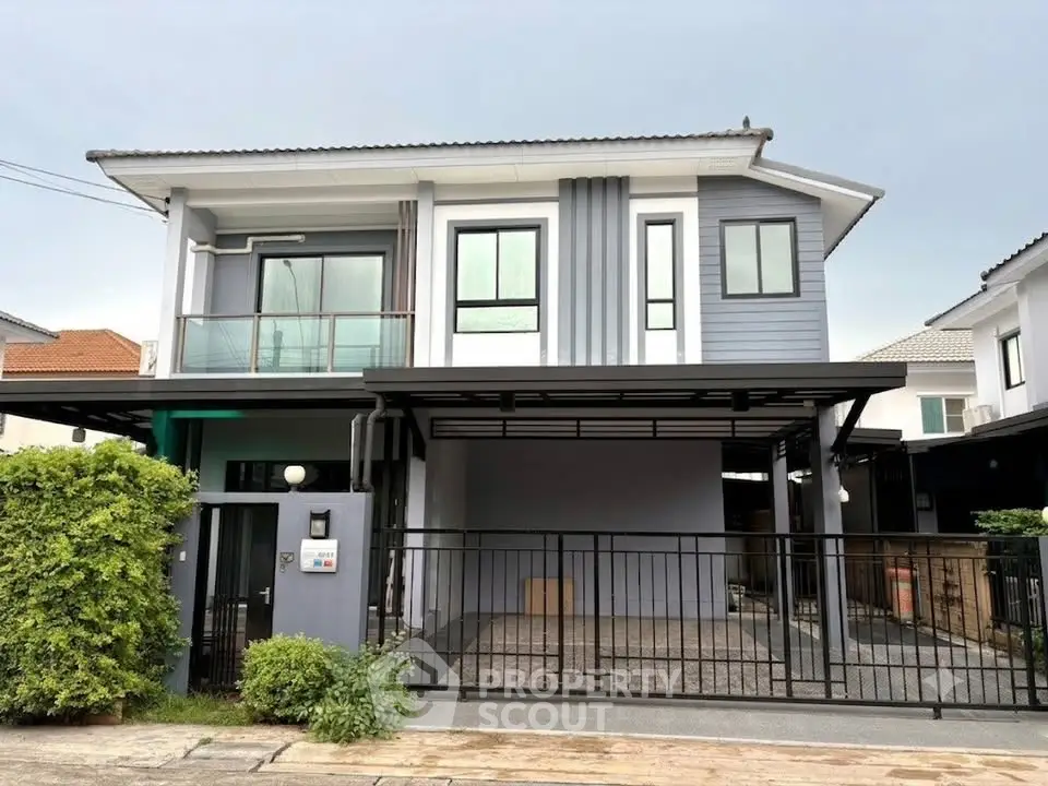 Modern two-story house with sleek design and spacious driveway in a suburban neighborhood.