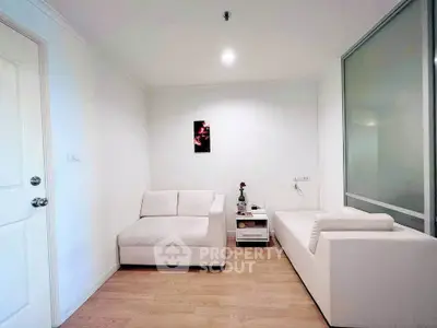 Modern minimalist living room with white sofas and wooden flooring