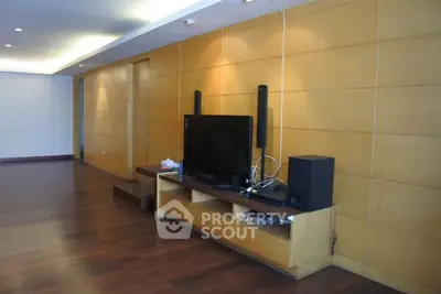 Spacious living room with modern entertainment setup and wooden flooring
