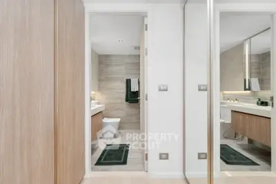 Modern bathroom with sleek design, featuring a large mirror and stylish fixtures.