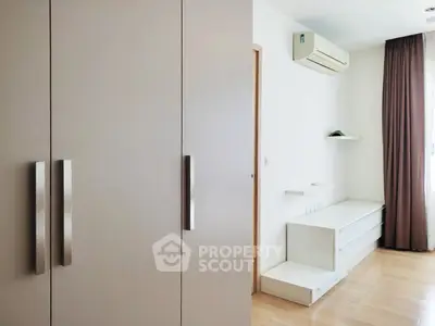 Modern bedroom with sleek storage and air conditioning in minimalist design.