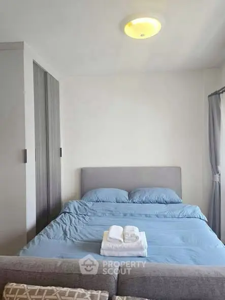 Cozy bedroom with modern decor and ample natural light, featuring a comfortable bed and stylish wardrobe.