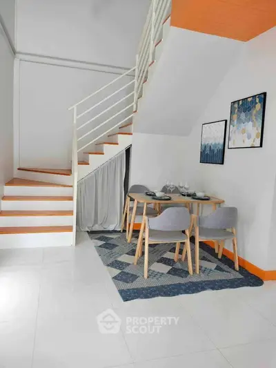 Modern duplex interior with stylish dining area and staircase, featuring contemporary decor and cozy ambiance.