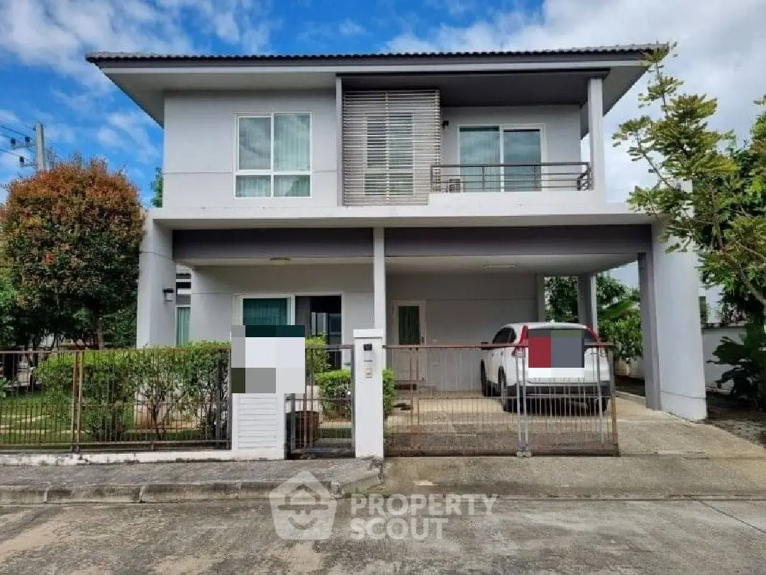 Modern two-story house with carport and lush greenery, ideal family home.