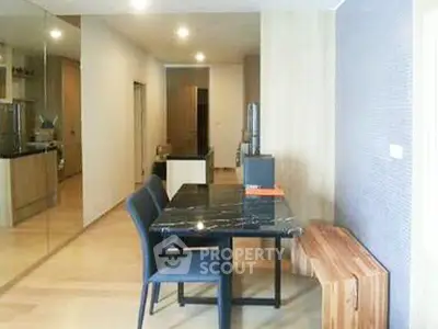 Modern dining area with sleek black table and stylish chairs in a contemporary apartment.