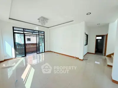 Spacious modern living room with large windows and balcony access, perfect for natural light lovers.
