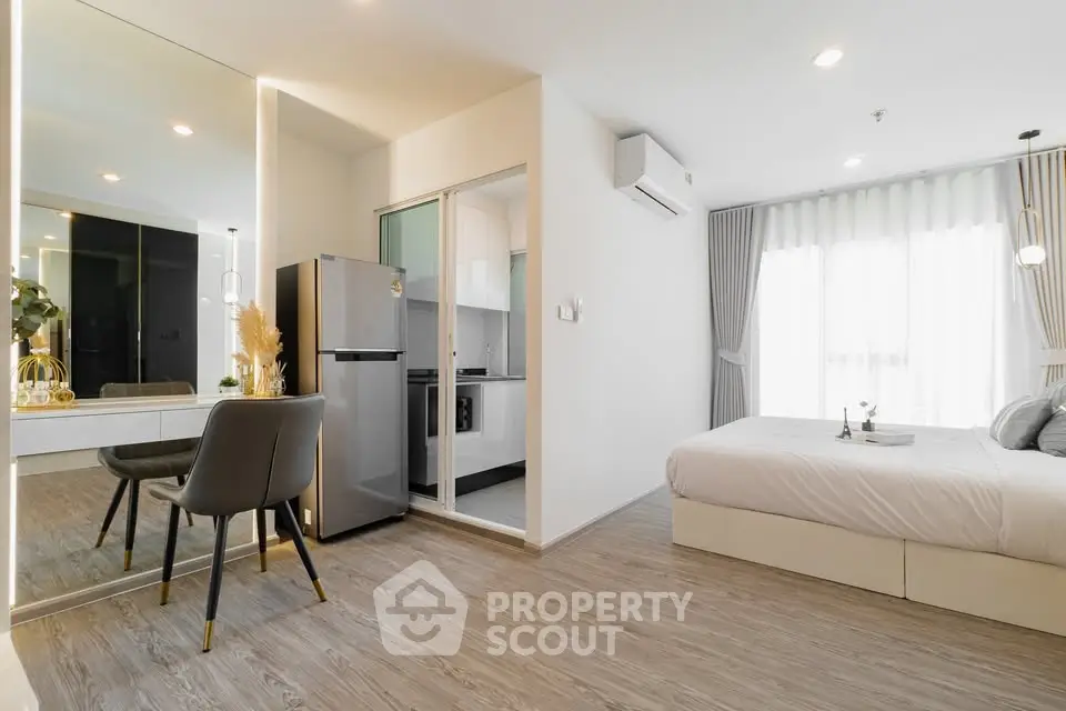 Modern studio apartment with open layout, featuring a cozy bedroom and compact kitchen area.