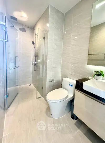 Modern bathroom with glass shower and sleek fixtures in luxury apartment