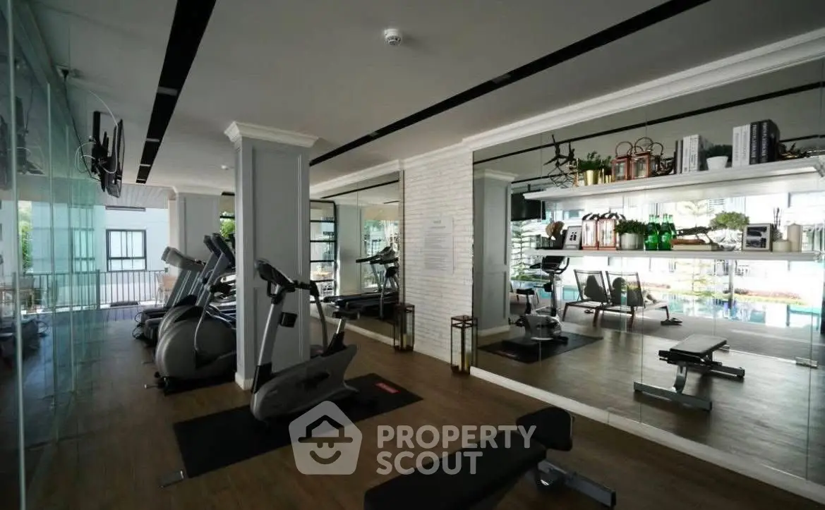 Modern gym with state-of-the-art equipment and mirrored walls in luxury apartment complex.