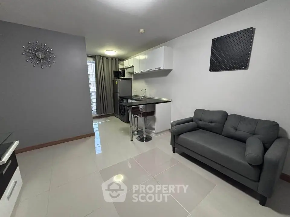 Modern studio apartment with sleek kitchen and cozy living area, perfect for urban living.