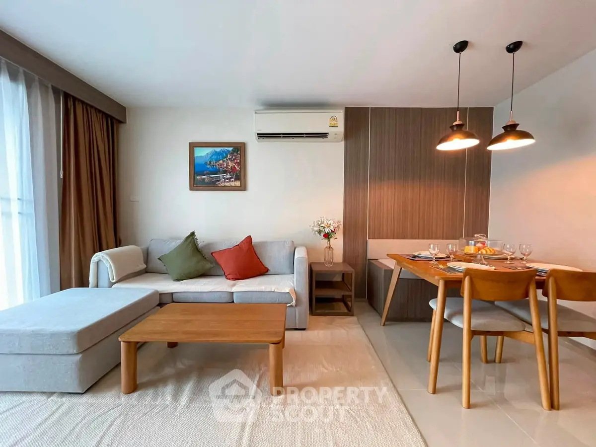 Modern living room with cozy seating and elegant dining area, perfect for relaxation and entertaining.