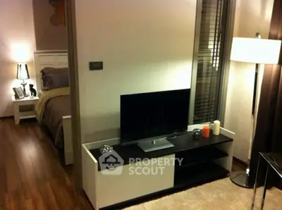 Modern bedroom with stylish decor and flat-screen TV, featuring cozy lighting and elegant furnishings.