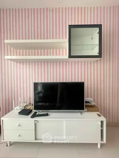 Modern living room with stylish TV stand and wall-mounted shelves against striped wallpaper.