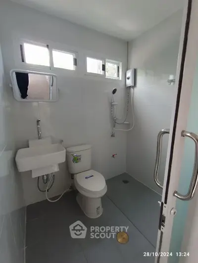 Modern bathroom with shower and toilet in bright white tiles