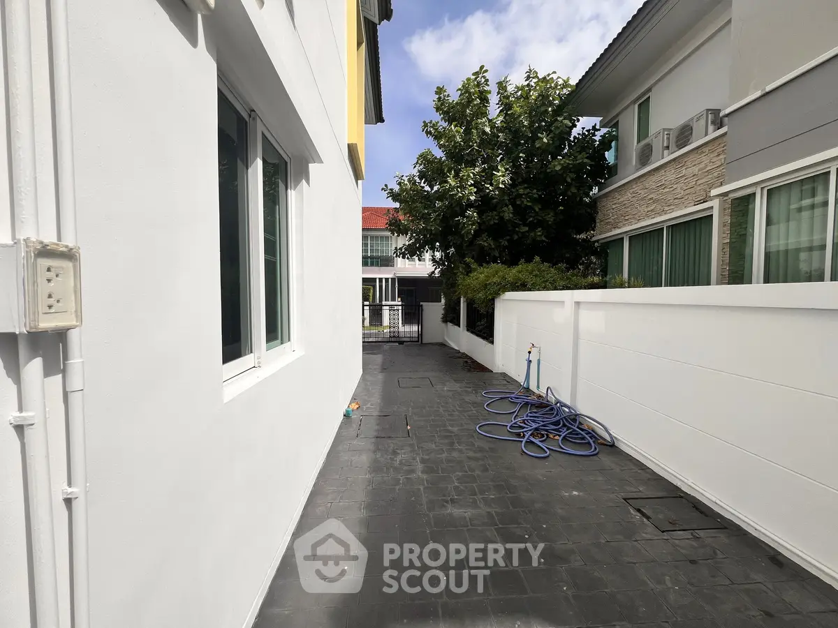 Modern residential exterior with clean white walls and spacious walkway, perfect for urban living.