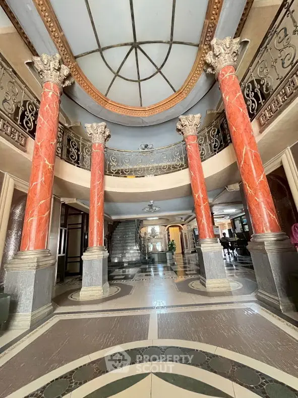 Luxurious grand entrance with ornate columns and elegant staircase