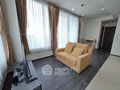 Spacious living room with large windows and modern furnishings in a contemporary apartment.