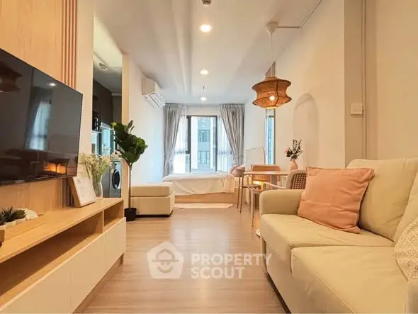 Modern living room with cozy seating and stylish decor in open layout apartment.